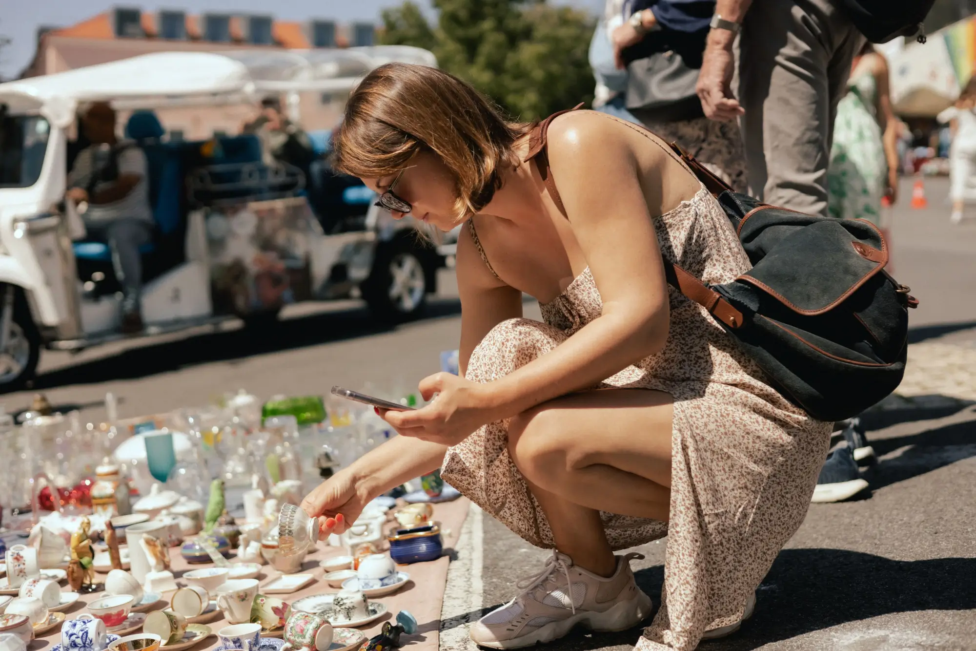Žena středního věku prohlížící staré nádobí na bleším trhu