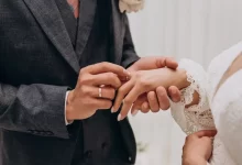 Mužská ruka navlékající prsten na ženskou ruku