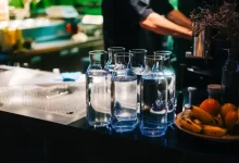 Vyskládané karafy s pitnou kohoutkovou vodou na pultíku restaurace