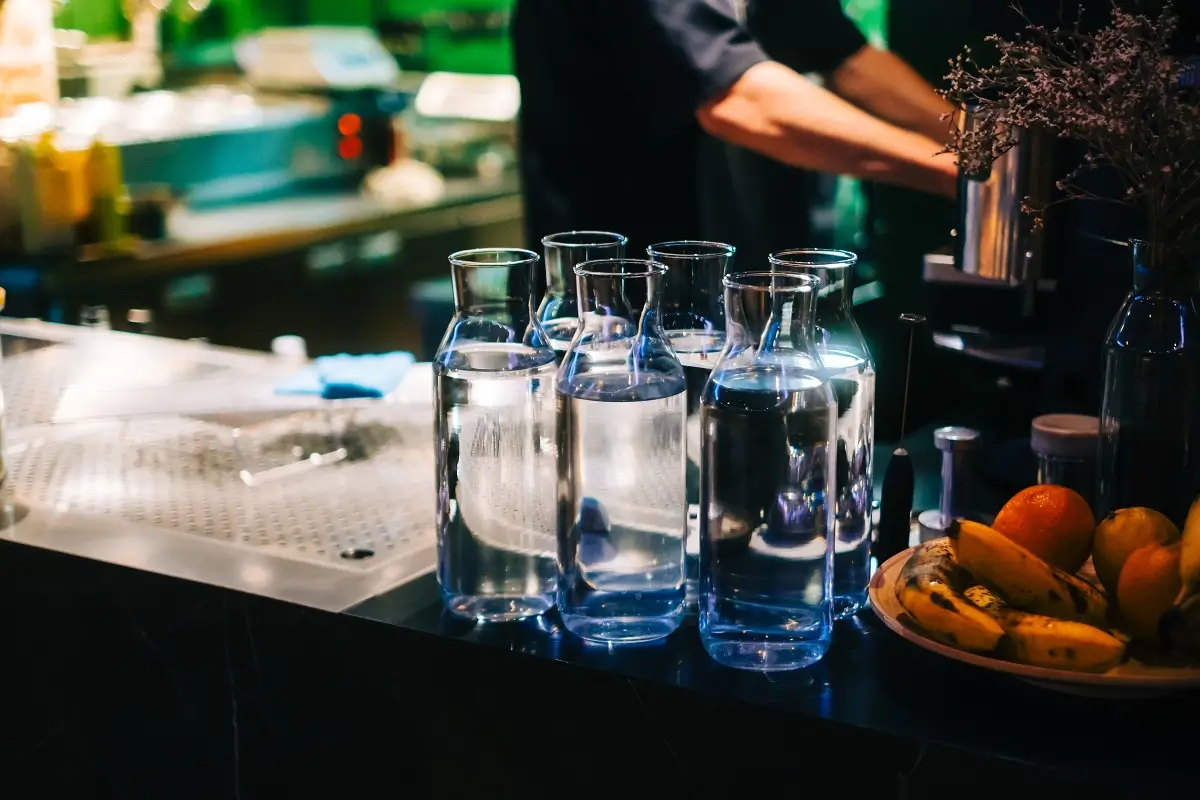 Vyskládané karafy s pitnou kohoutkovou vodou na pultíku restaurace