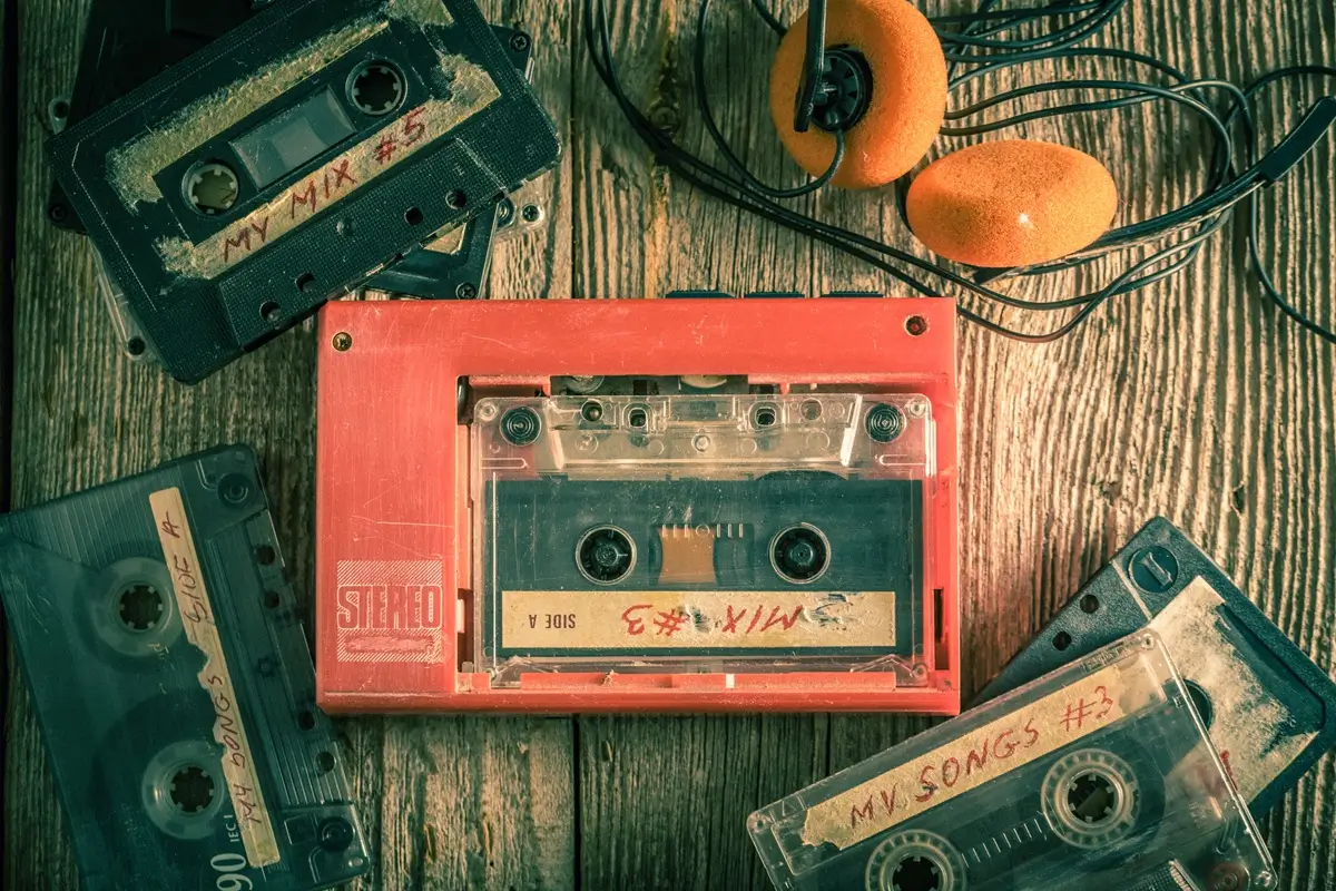 Staré kazety s přehrávačem se sluchátky ležící na retro stole