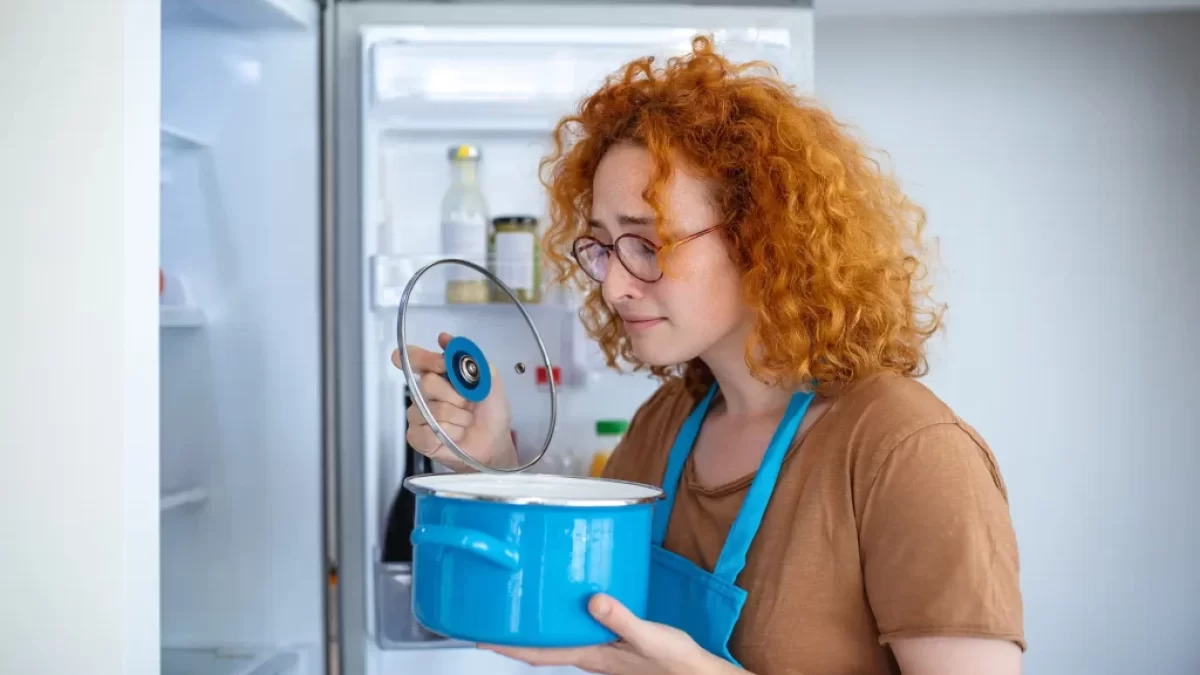žena ohrnuje nos nad jídlem v hrnci