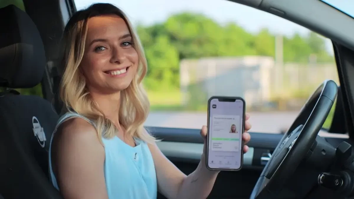 Dívka s řidičským průkazem v mobilu.