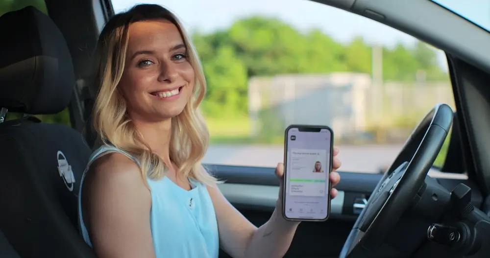 Dívka s řidičským průkazem v mobilu.