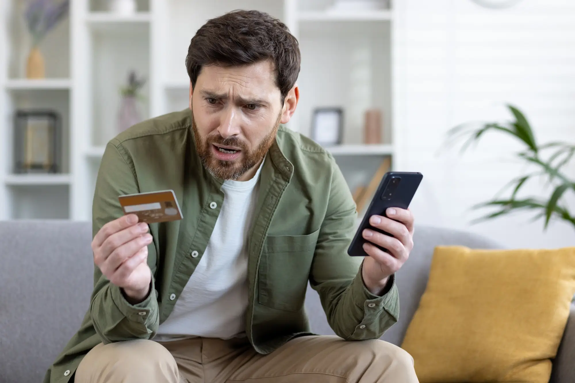 Nešťastný muž s kreditní kartou a mobilem
