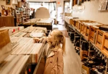 Malá holčička si prohlíží regály plné starých vinylových desek
