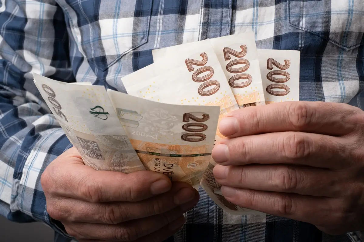 Penze 3 - SportDeník Mužské ruce seniora drží několik dvousetkorunových bankovek