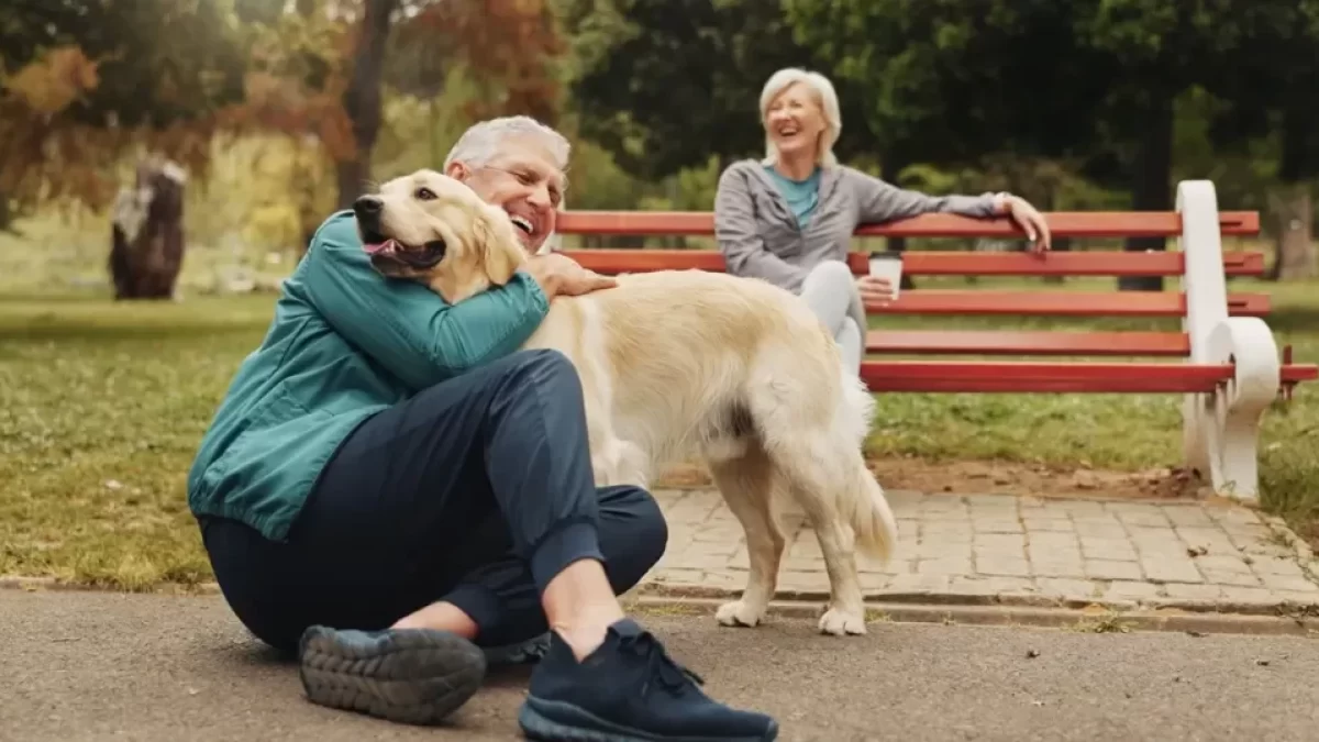 Pár seniorů si užívá na lavičce v parku svého čtyřnohého psího miláčka
