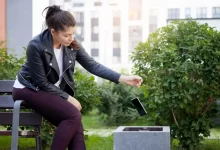 Žena vyhazující mobilní telefon do koše