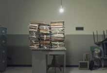 Stůl ve staré místnosti se stohy papírů a složek
