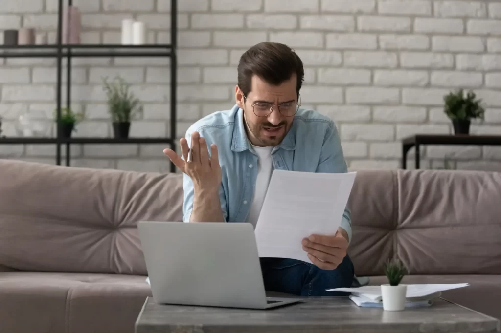 - SportDeník Muž čte dokument u notebooku a vypadá zmateně.