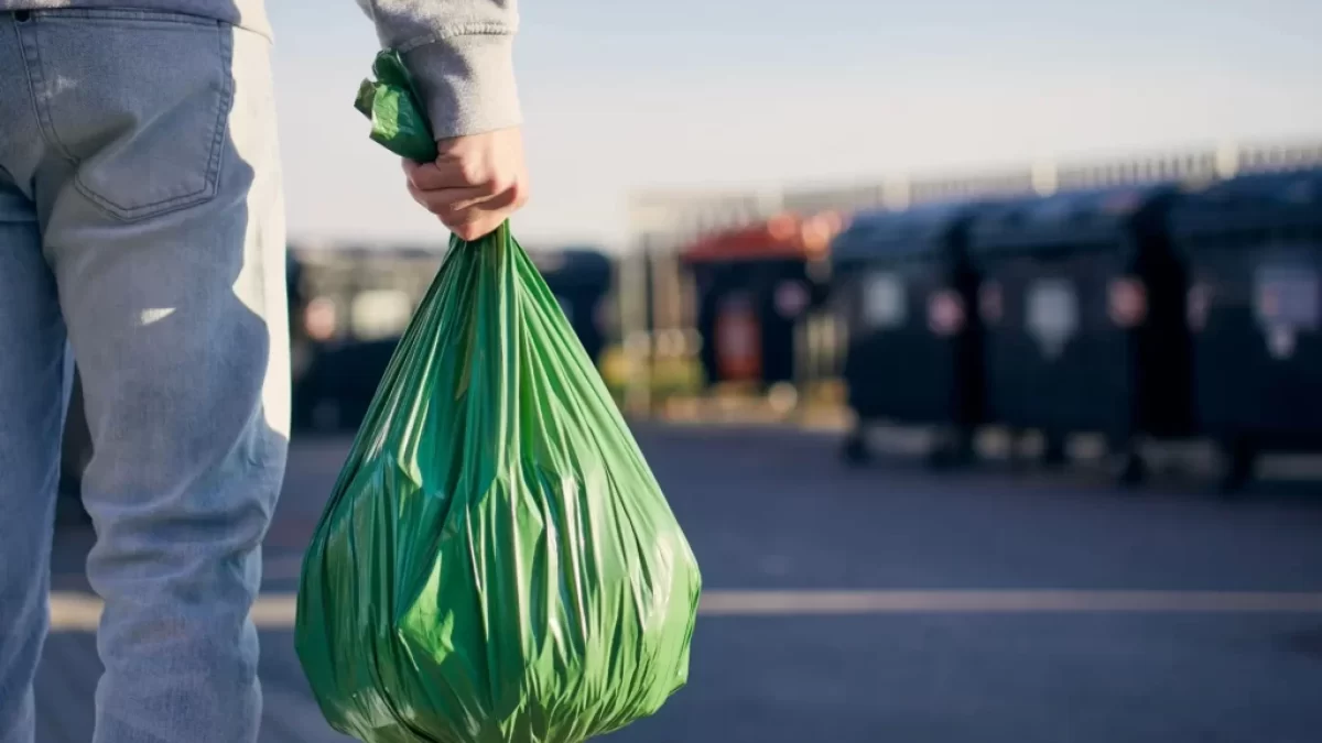 Muž jdoucí vyhodit pytel s odpadky