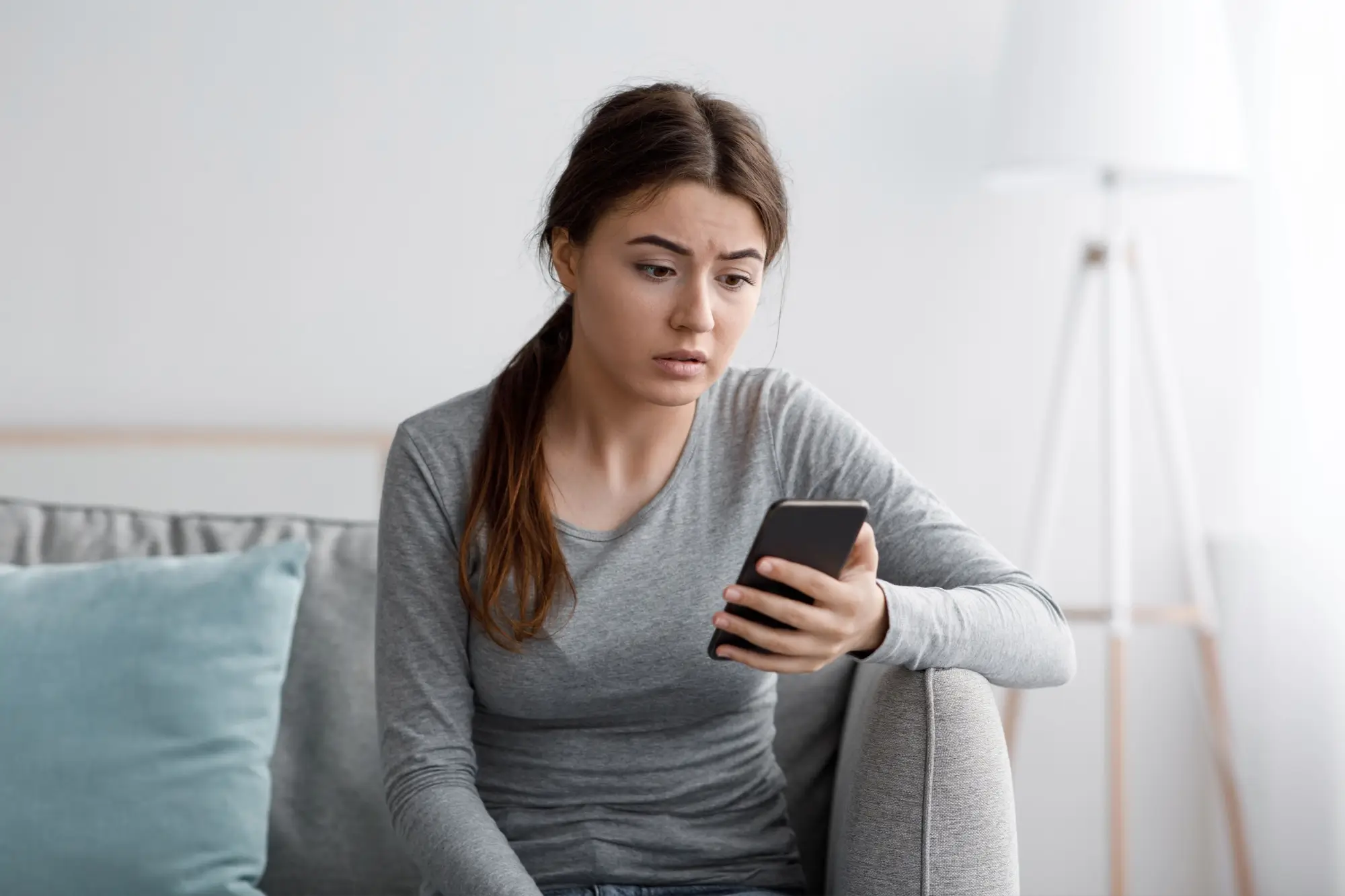 Žena sklesle kouká na mobil