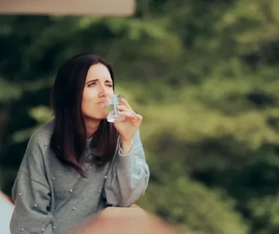 Žena s nechutí pijící vodu ze sklenice