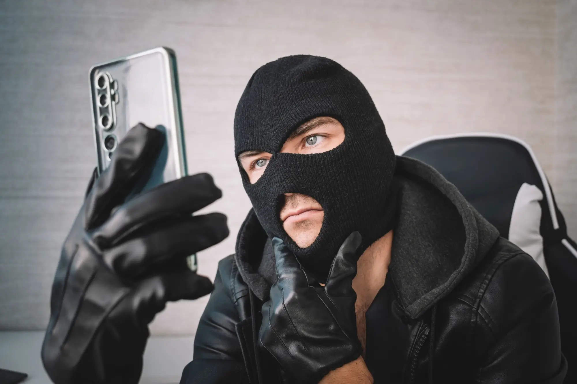 Shutterstock_2202653909 - SportDeník Maskovaný muž s telefonem