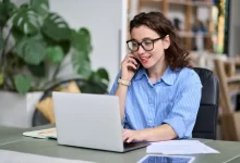 telefonující žena za notebookem