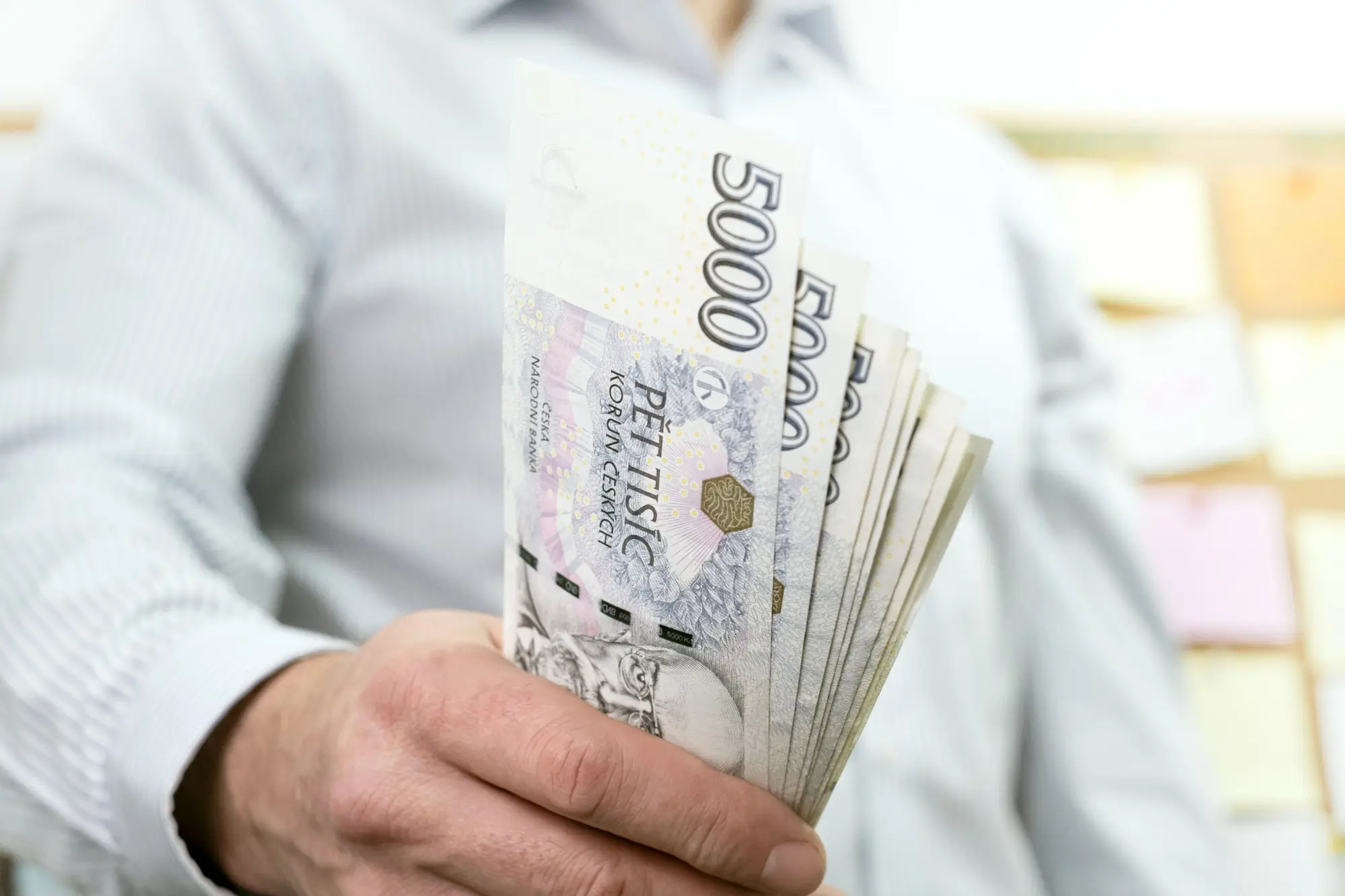 Shutterstock_2255055797 - SportDeník Muž držící pětitisícové bankovky