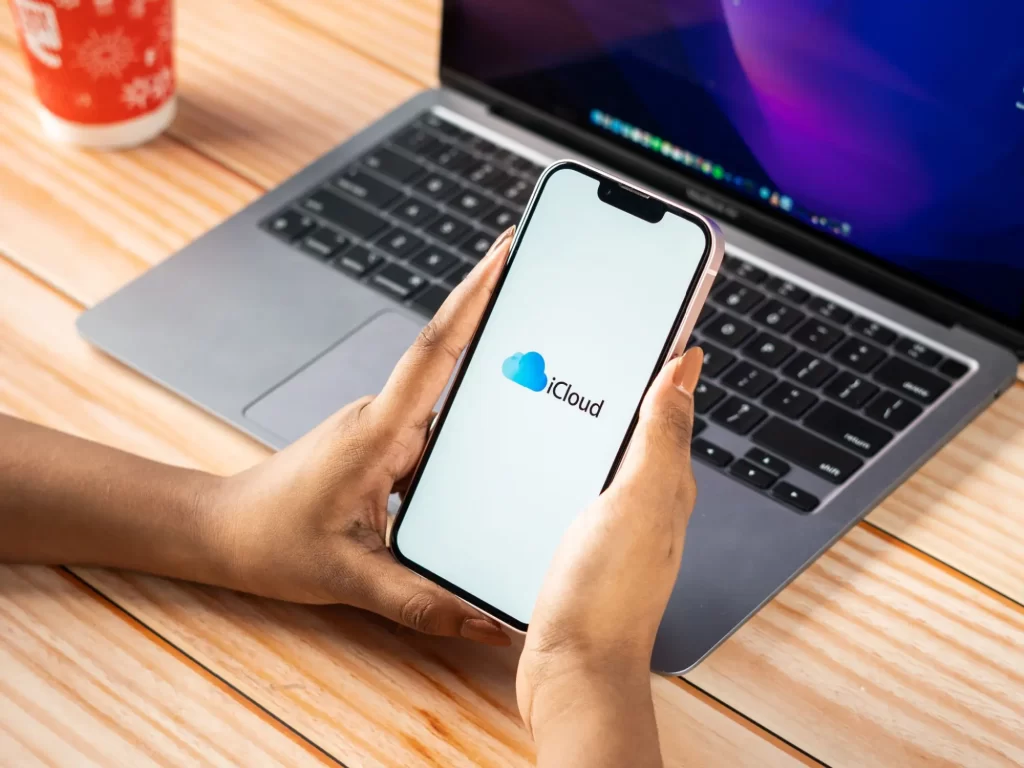 Shutterstock_2327822959 - SportDeník Muž držící chytrý telefon s logem iCloud na displeji