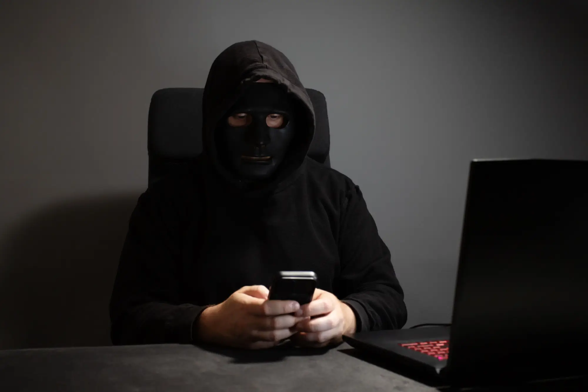 Shutterstock_2473044857 - SportDeník Maskovaný muž s mobilním telefonem v rukou