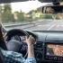 Řidička sleduje silnici při jízdě autem, pohled z interiéru na čelní sklo a zpětné zrcátko.