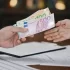 Změna měny na euro, muž předává peníze druhému