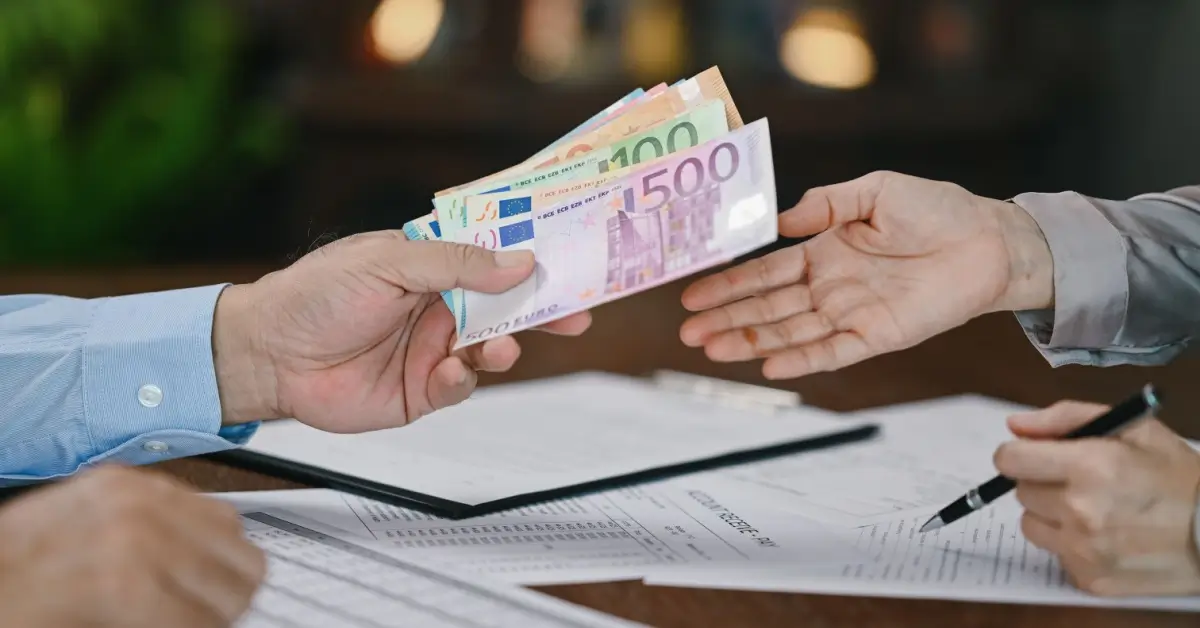 Změna měny na euro, muž předává peníze druhému