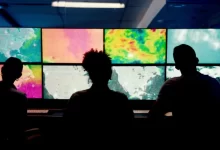 Meteorologové sedí o počítačů, které vyhodnocují počasí