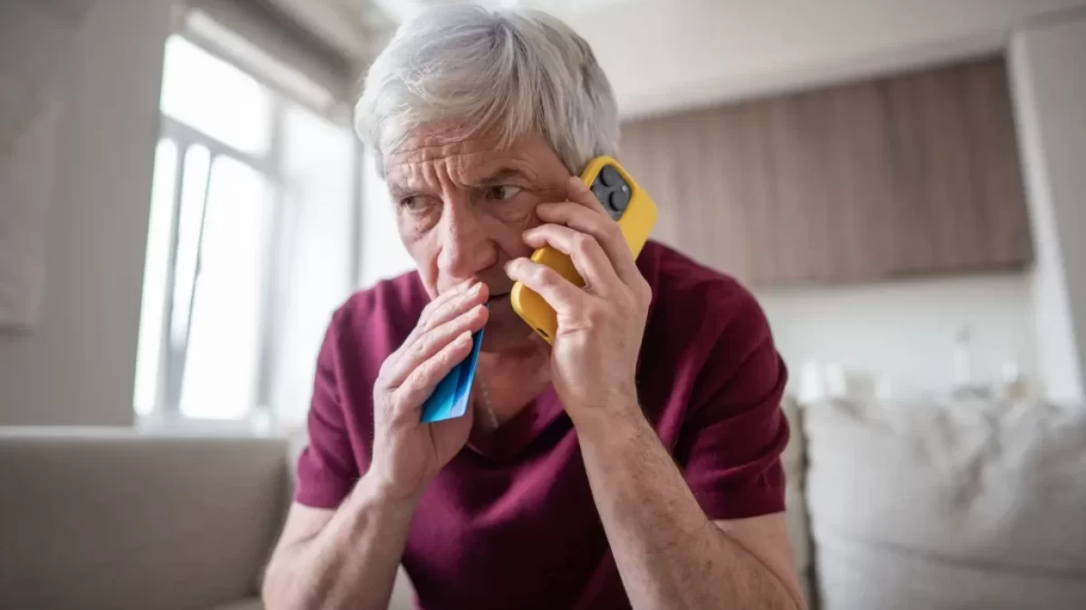 Telefonující senior s platební kartou