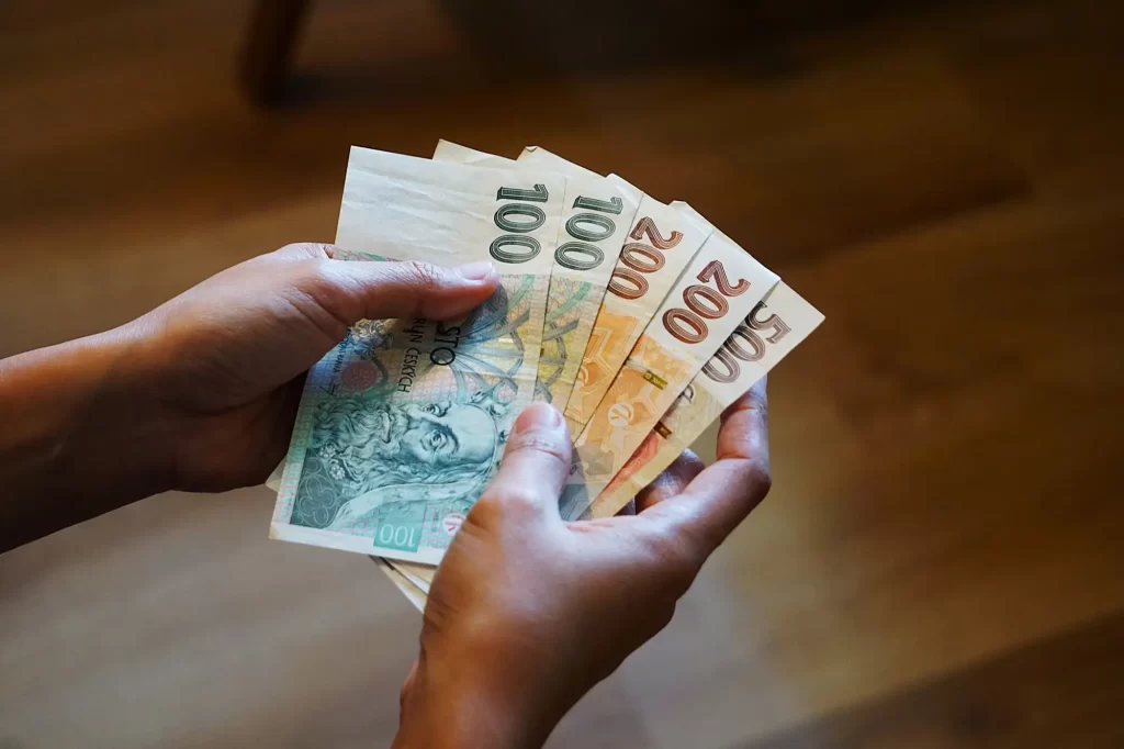 Žena drží v ruce peníze