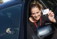 Žena za volantem ukazuje řidičský průkaz
