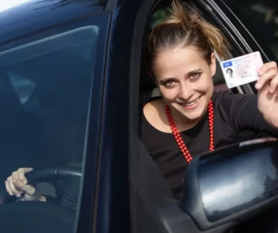 Žena za volantem ukazuje řidičský průkaz