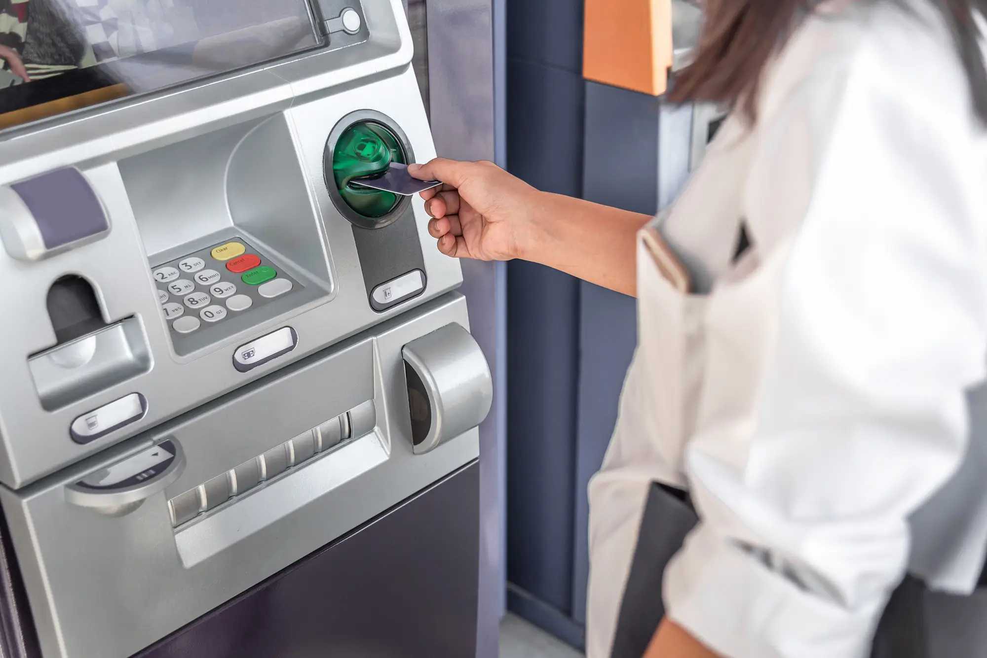 žena vybírá peníze u bankomatu