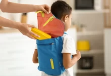 maminka dává synovi svačinu do batohu