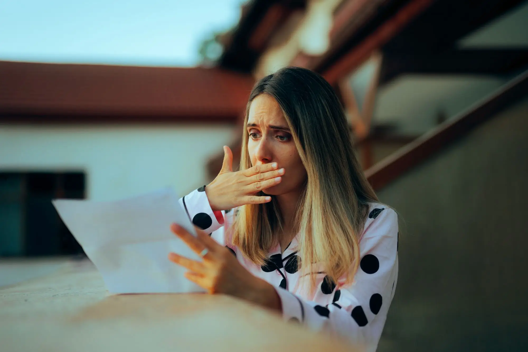 nepříjemně udivená žena s dopisem v ruce