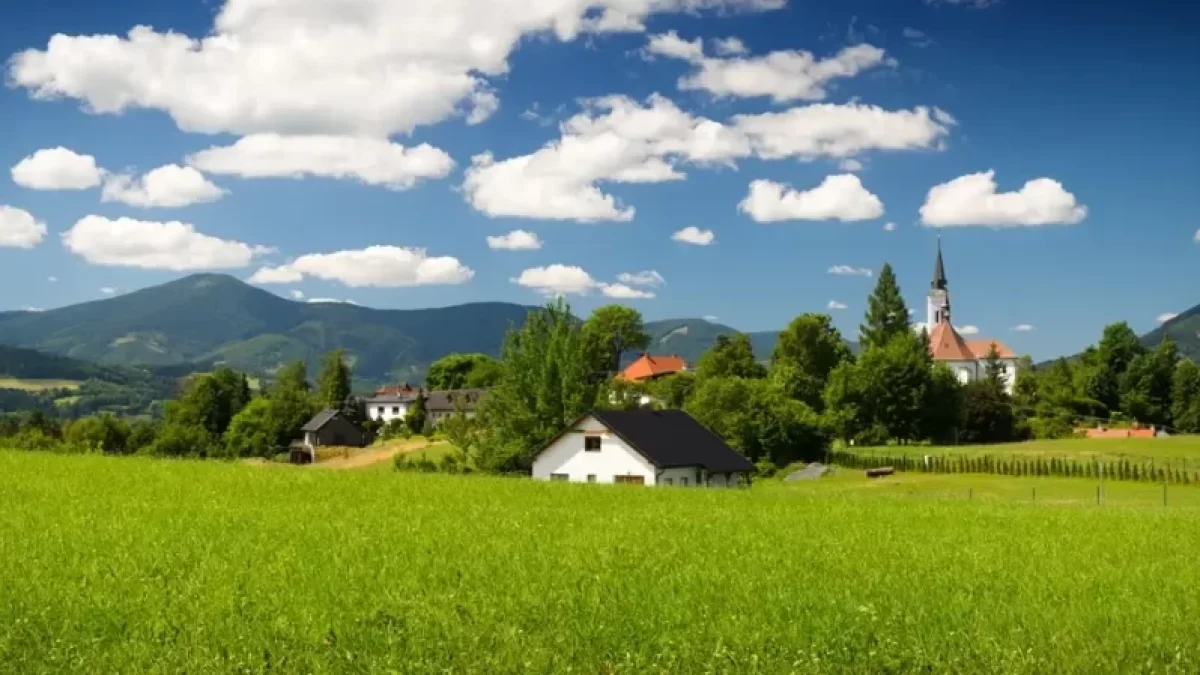 Pohled na Beskydy v oblasti Těšínska, slunečný den, v pozadí kostelík a vesnička