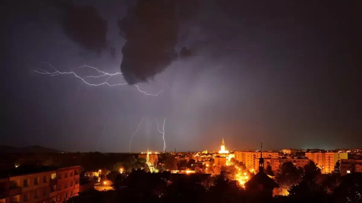 Noční město a nad ním blesky a silná bouřka
