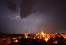 Noční město a nad ním blesky a silná bouřka
