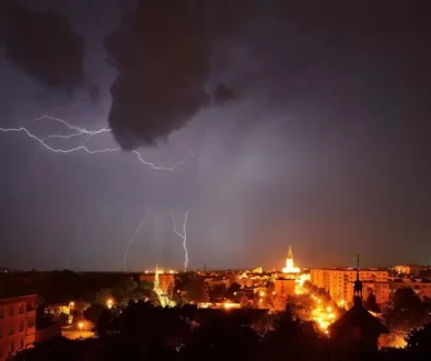 Noční město a nad ním blesky a silná bouřka