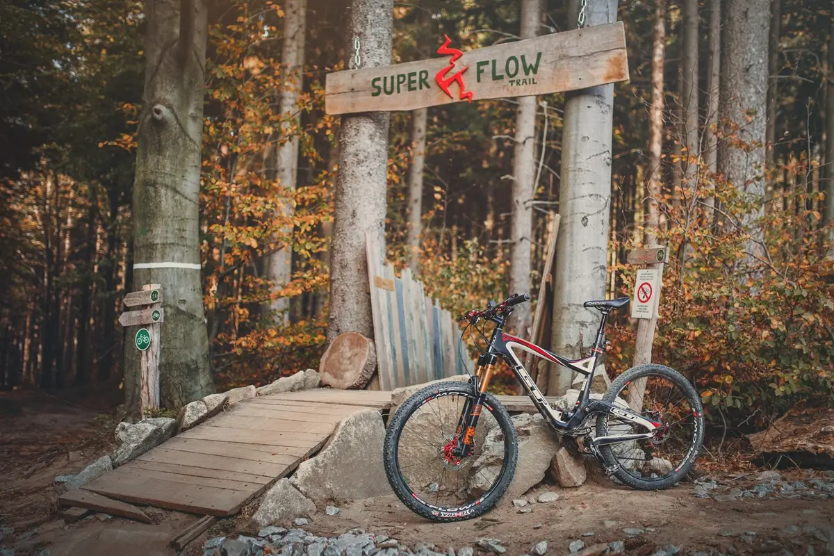 Rychlebské hory - SportDeník Trailové kolo opřené o bránu do jednoho z adrenalinových parků pro bikery v Rychlebských horách