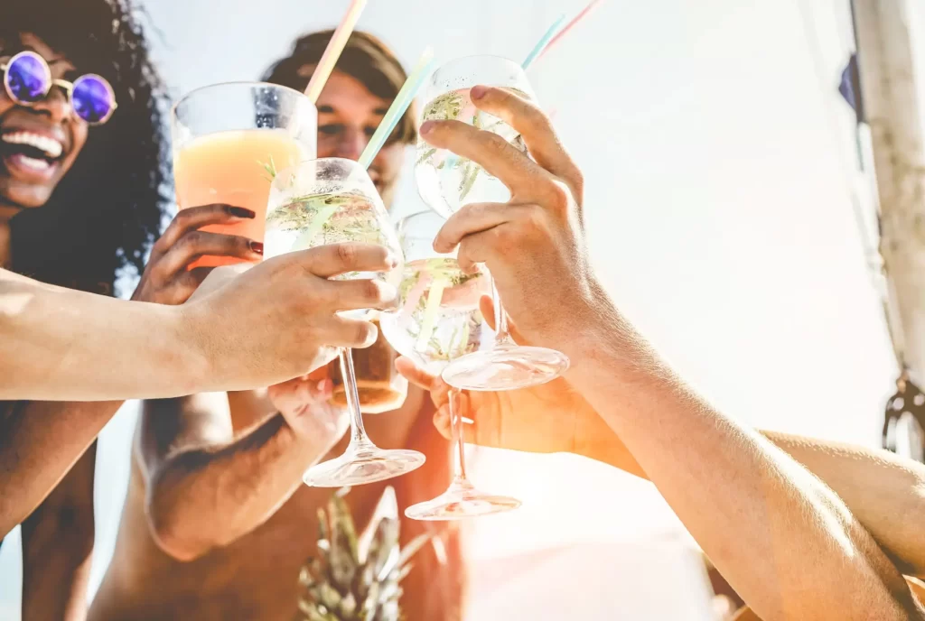 - SportDeník Skupina lidí s drinky během letního dne.