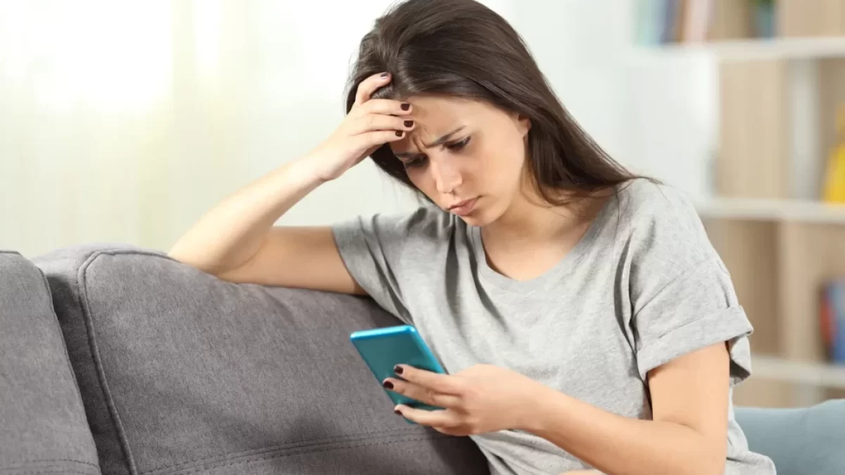 Nepříliš šťastná žena s mobilním telefonem