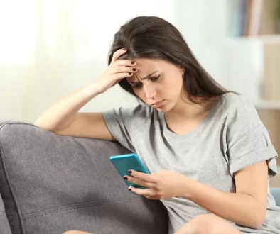 Nepříliš šťastná žena s mobilním telefonem