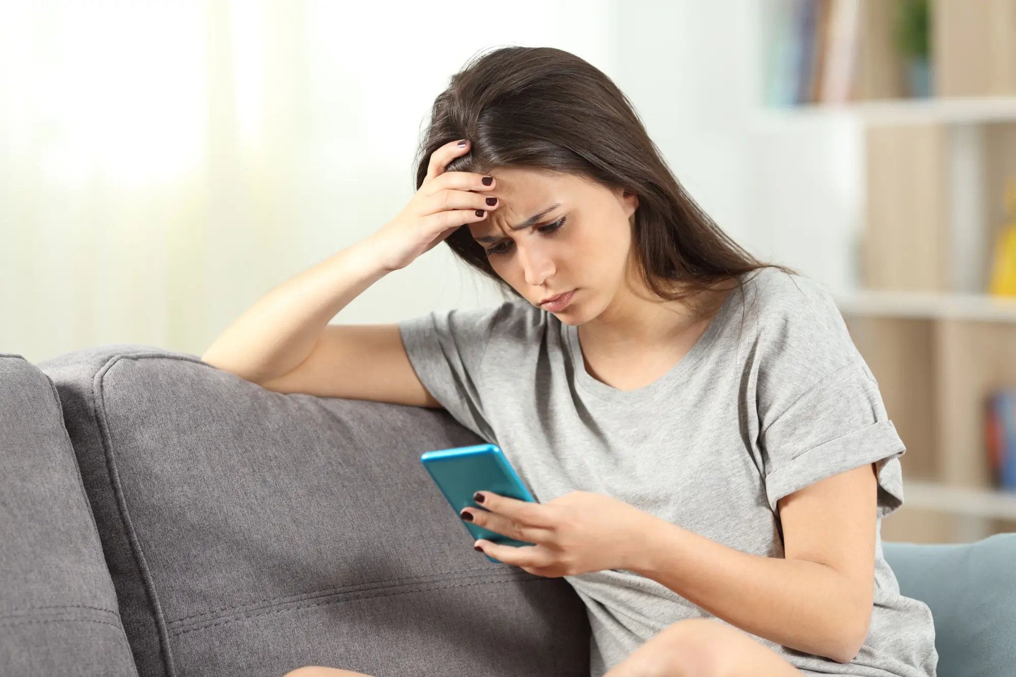Nepříliš šťastná žena s mobilním telefonem