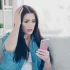 Zděšená žena koukající do mobilu