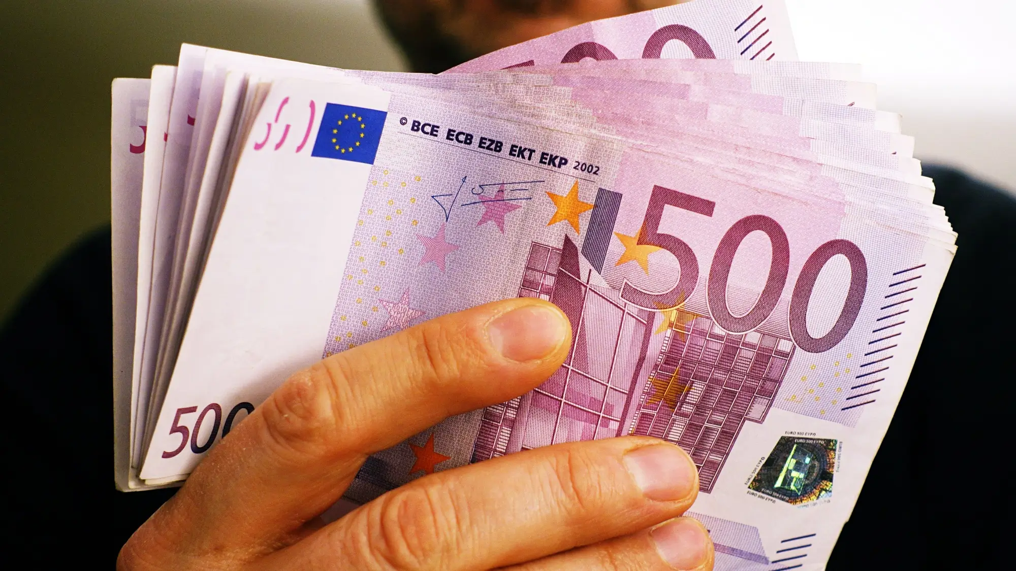 Shutterstock_1771855352 - SportDeník Muž drží 10 tisíc euro