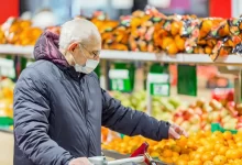 Senior vybírá v obchodě citrusy