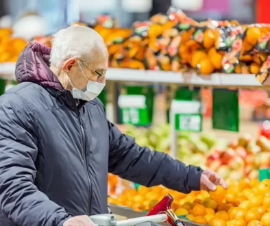 Senior vybírá v obchodě citrusy