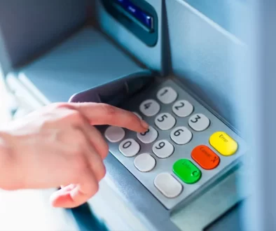 Detail ruky při ovládání tlačítek bankomatu.