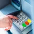 Detail ruky při ovládání tlačítek bankomatu.