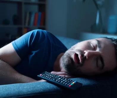 Muž spící při zapnuté televizi.